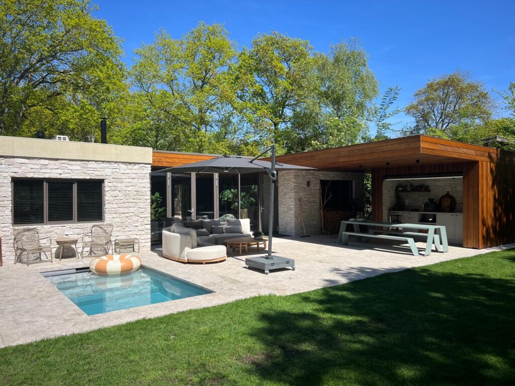 Compacte plunge pool op een terras naast een tuinhuis